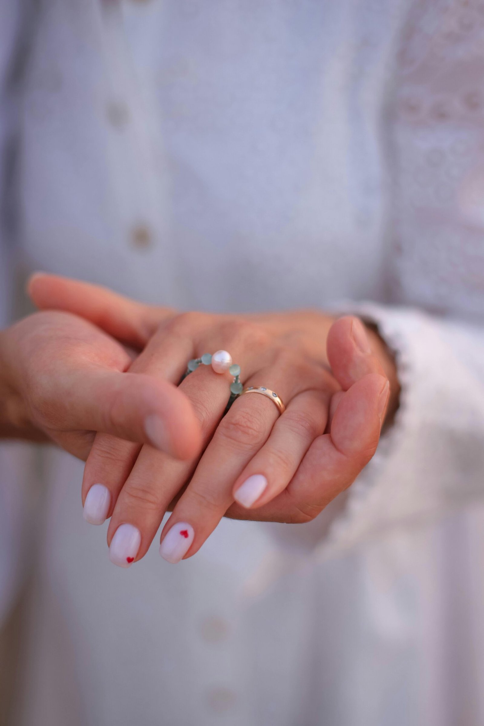 Nail art élégant réalisé au salon LEA BEAUTY avec vernis nude et petit cœur rouge - manucure professionnelle